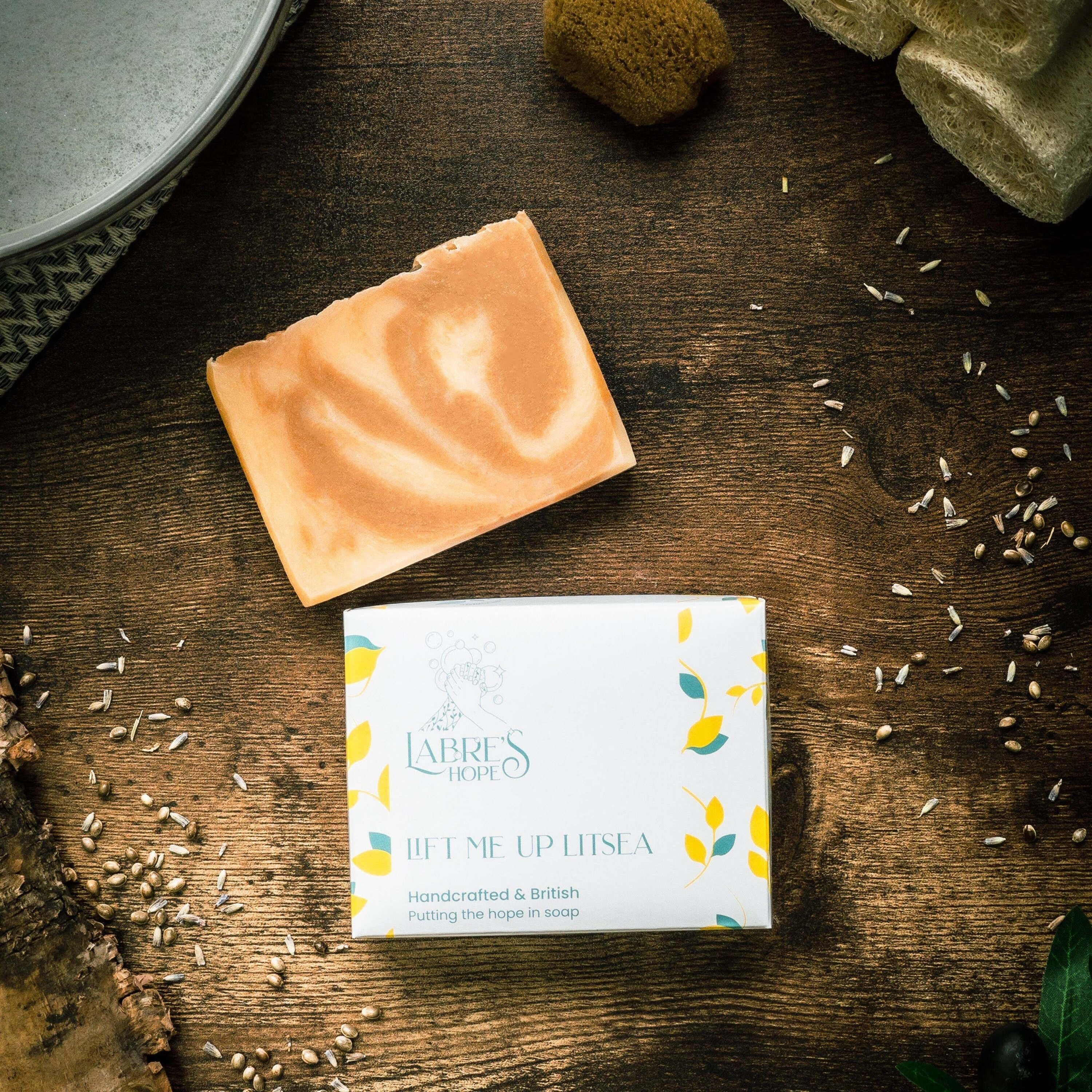 Bar of soap and its packaging on a wooden surface with natural elements.