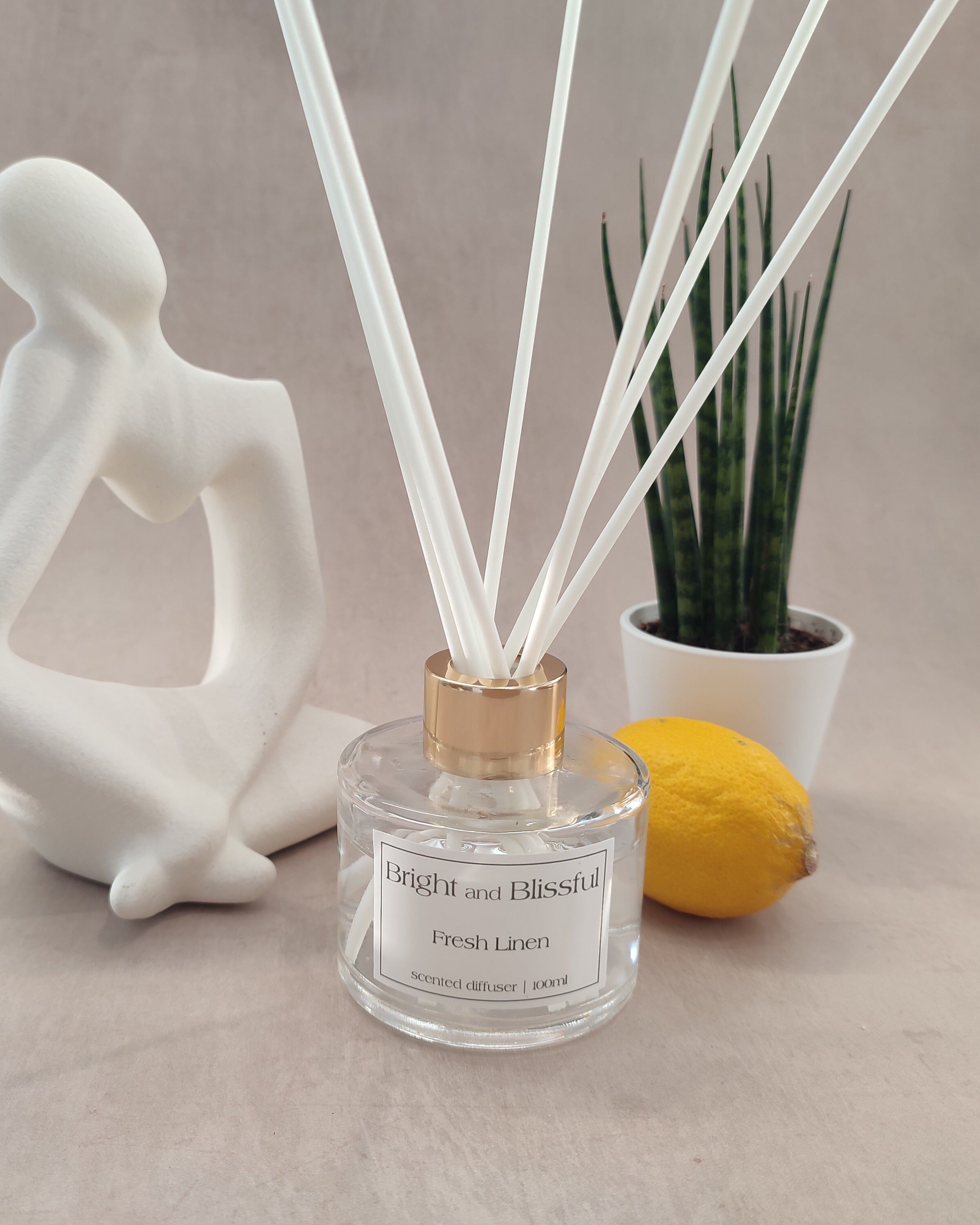 Reed diffuser labeled 'Bright and Blissful' with decorative elements on a neutral background