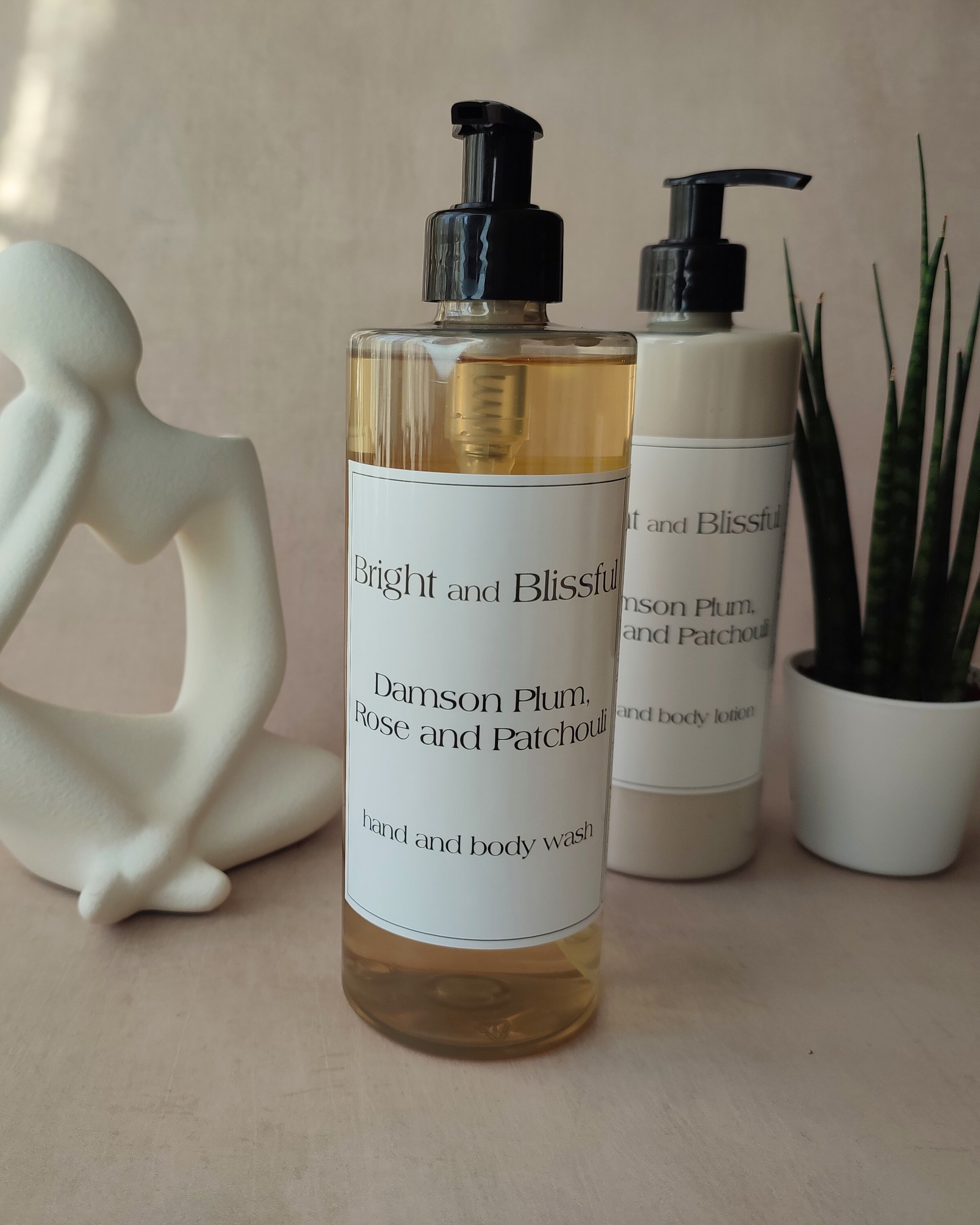 Two bottles of 'Bright and Blissful' body wash and lotion on a neutral background with decorative elements.
