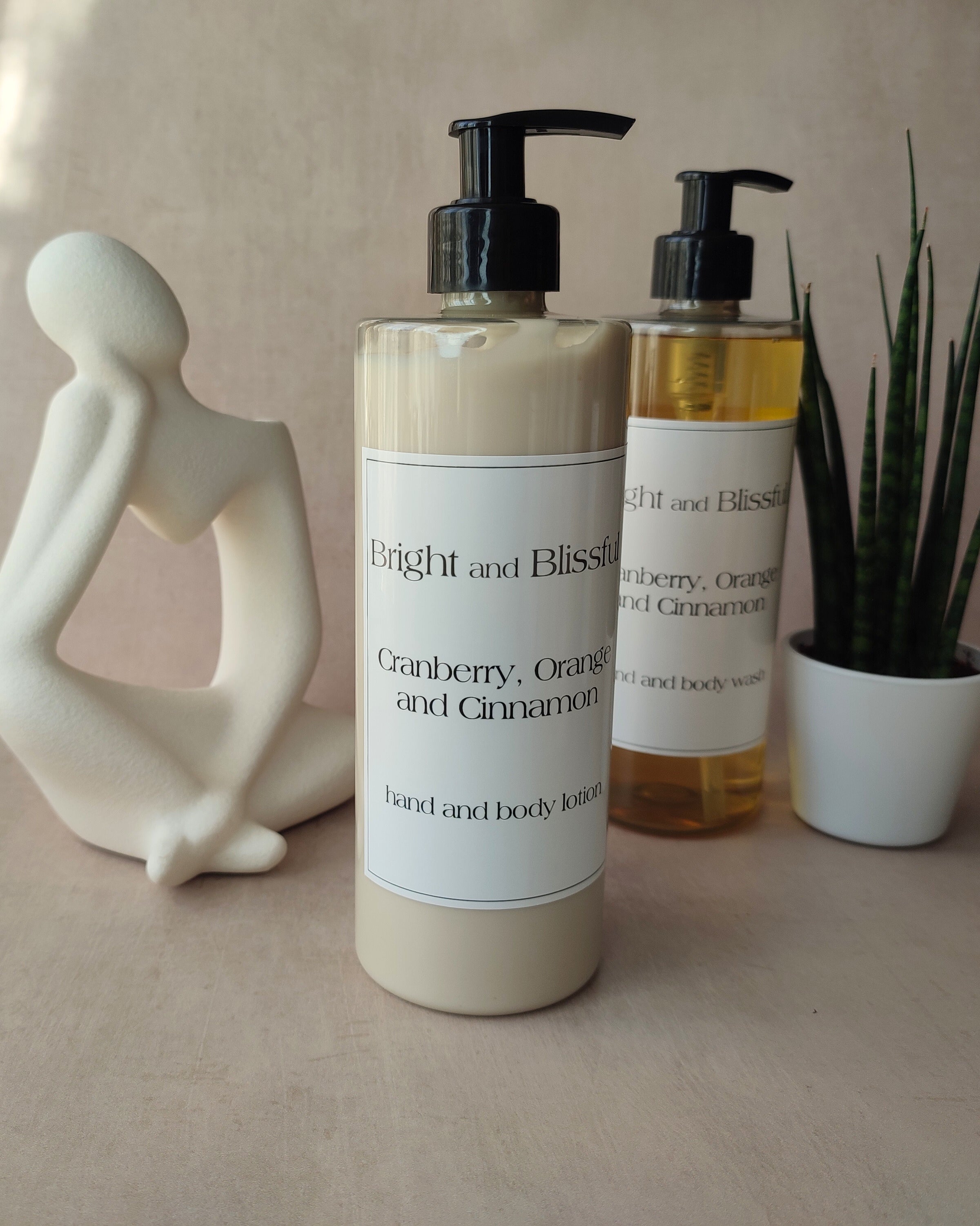 Two bottles of 'Bright and Blissful' hand and body lotion on a neutral background with decorative elements.