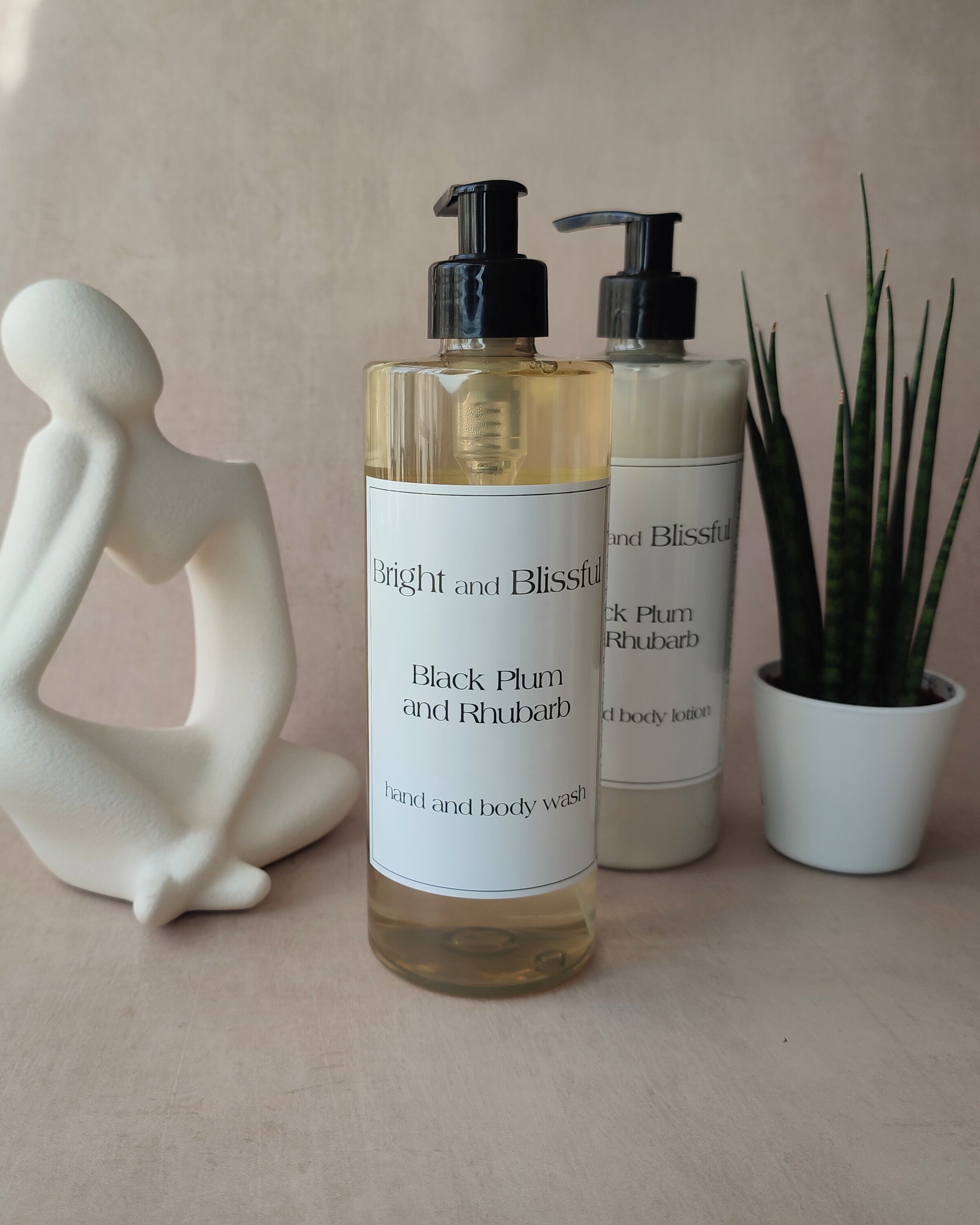 Two bottles of 'Bright and Blissful' body wash on a neutral surface with decorative items.