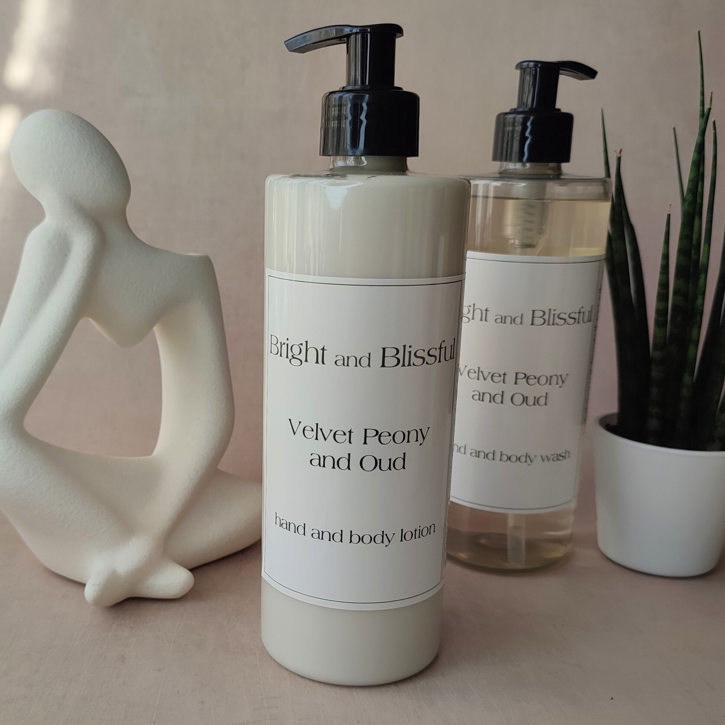 Two bottles of 'Bright and Blissful' body wash on a neutral surface with decorative items.