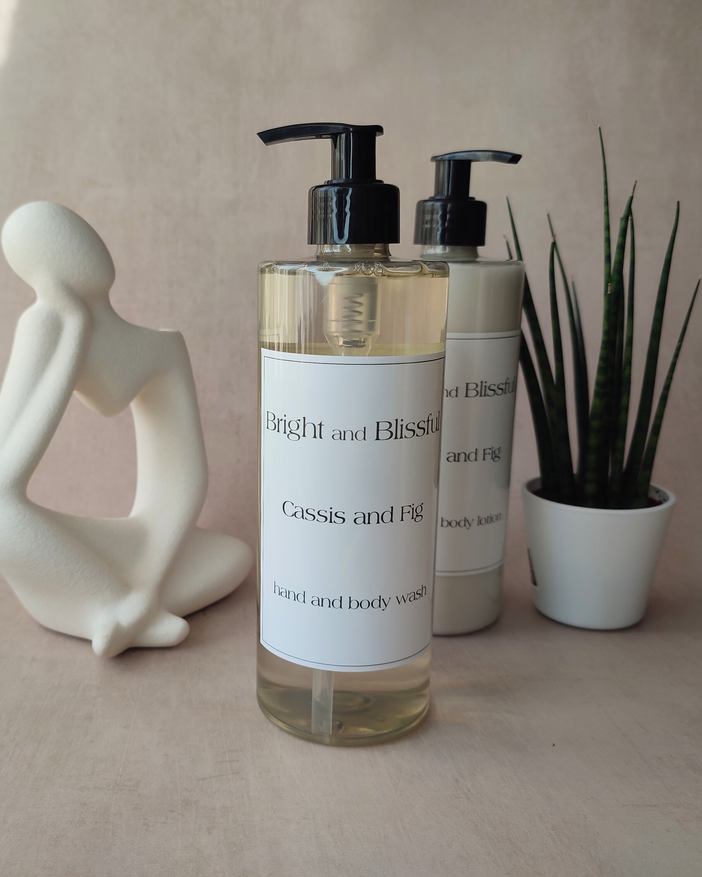Two bottles of 'Bright and Blissful' body wash and lotion on a neutral background with decorative elements.