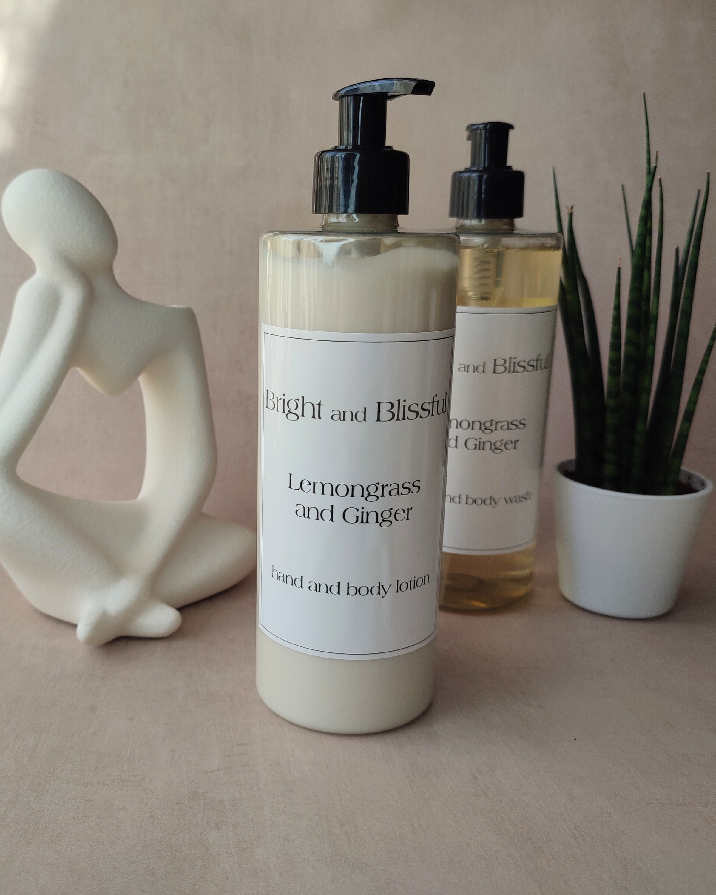 Two bottles of 'Bright and Blissful' products on a neutral background with a decorative figure and plant.