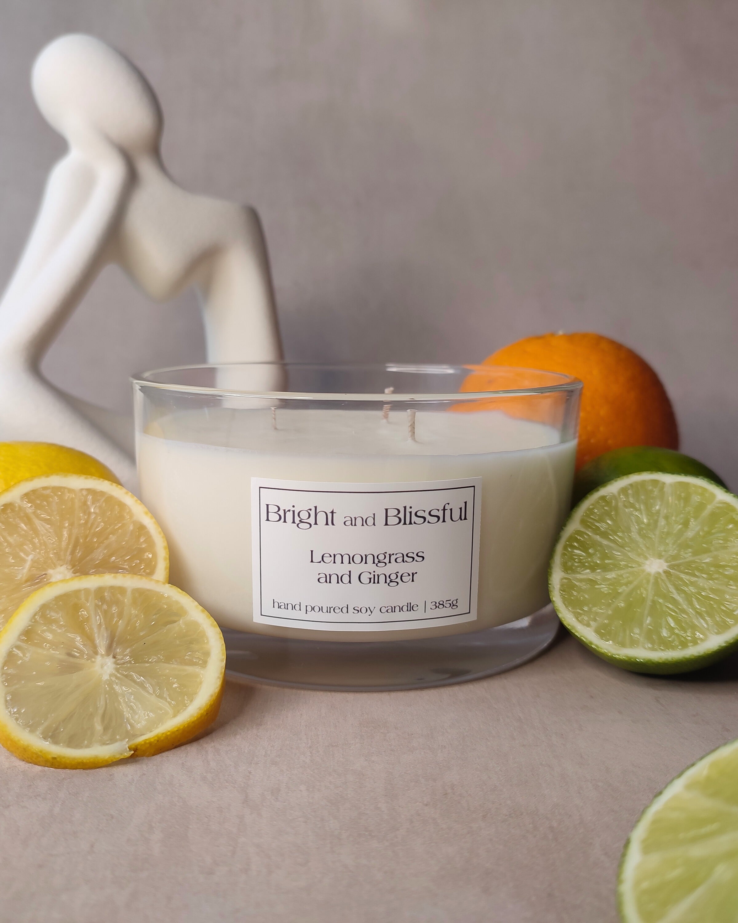 Candle labeled 'Bright and Blissful' with lemons and oranges on a neutral background