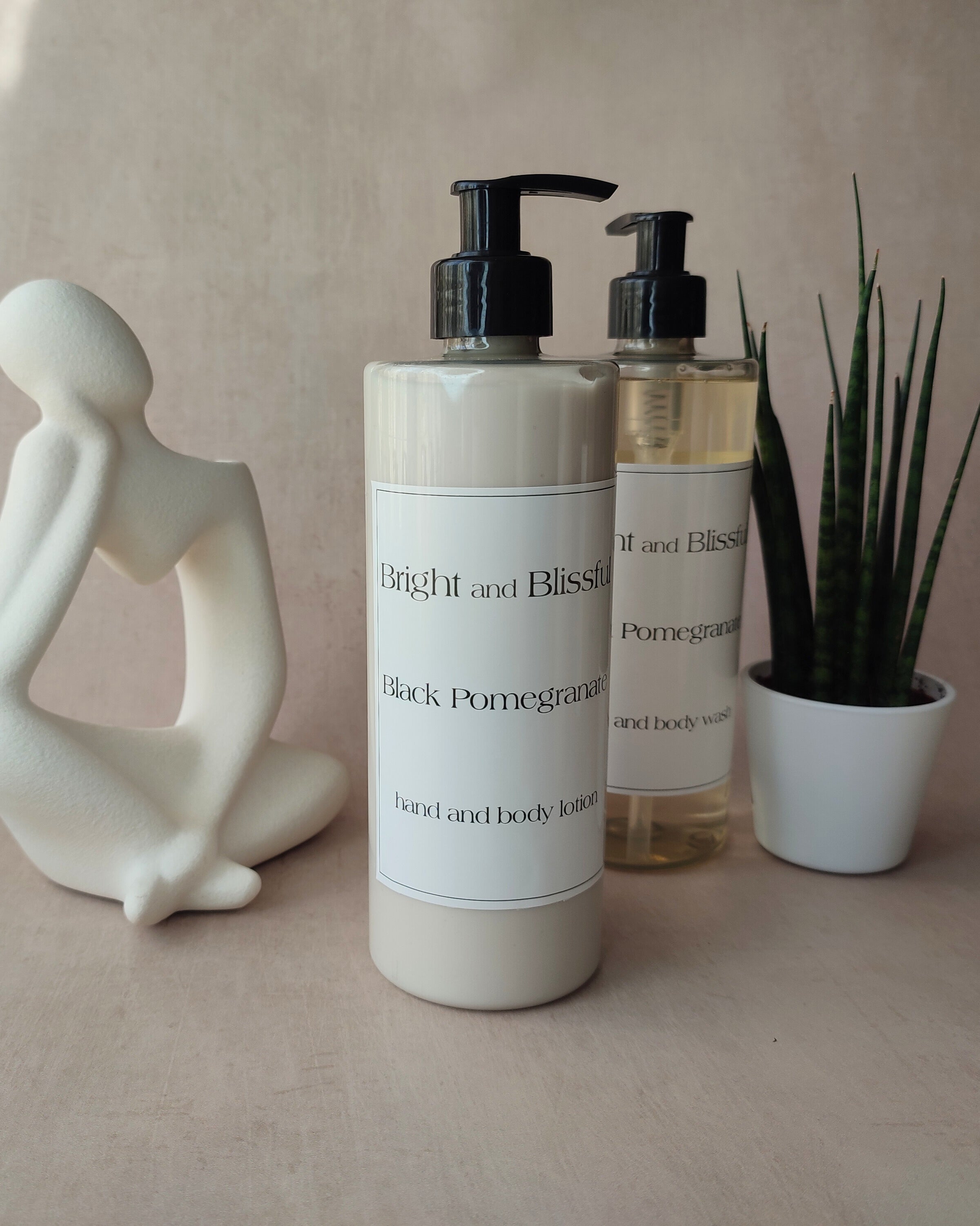 Two bottles of 'Bright and Blissful' products on a neutral surface with a decorative figure and plant.