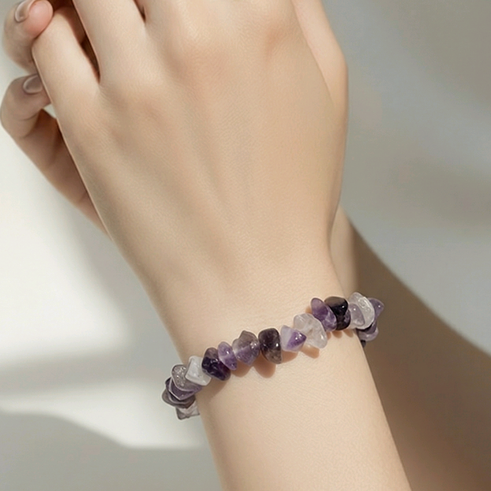 Amethyst chip bracelet with purple stones on a neutral background