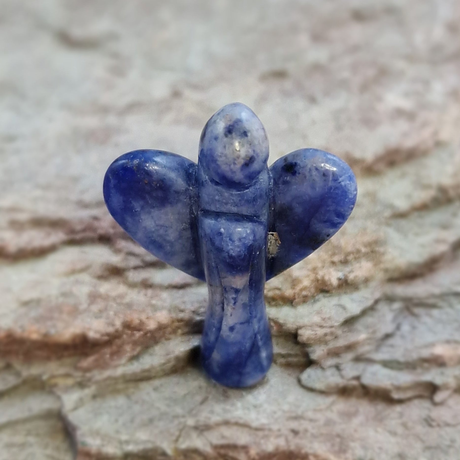Blue Spot Jasper Crystal Angel object on a textured surface