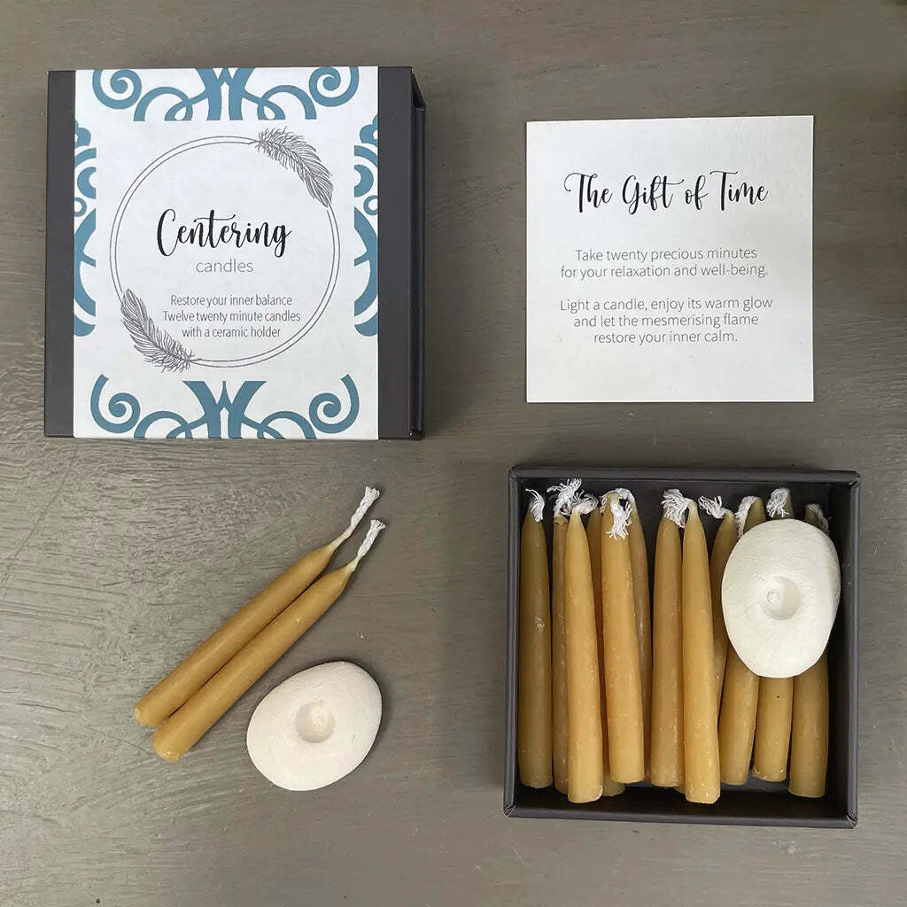 Set of beeswax candles with packaging and instructions on a wooden surface
