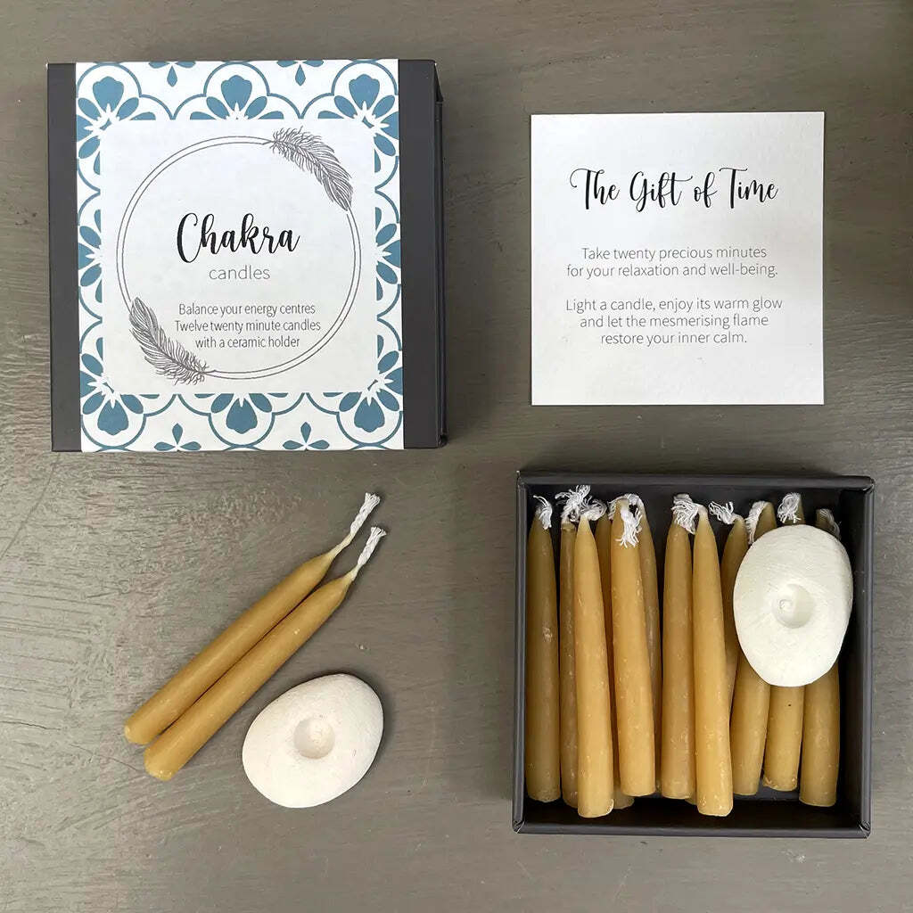 Chakra candles with packaging and instructions on a wooden surface
