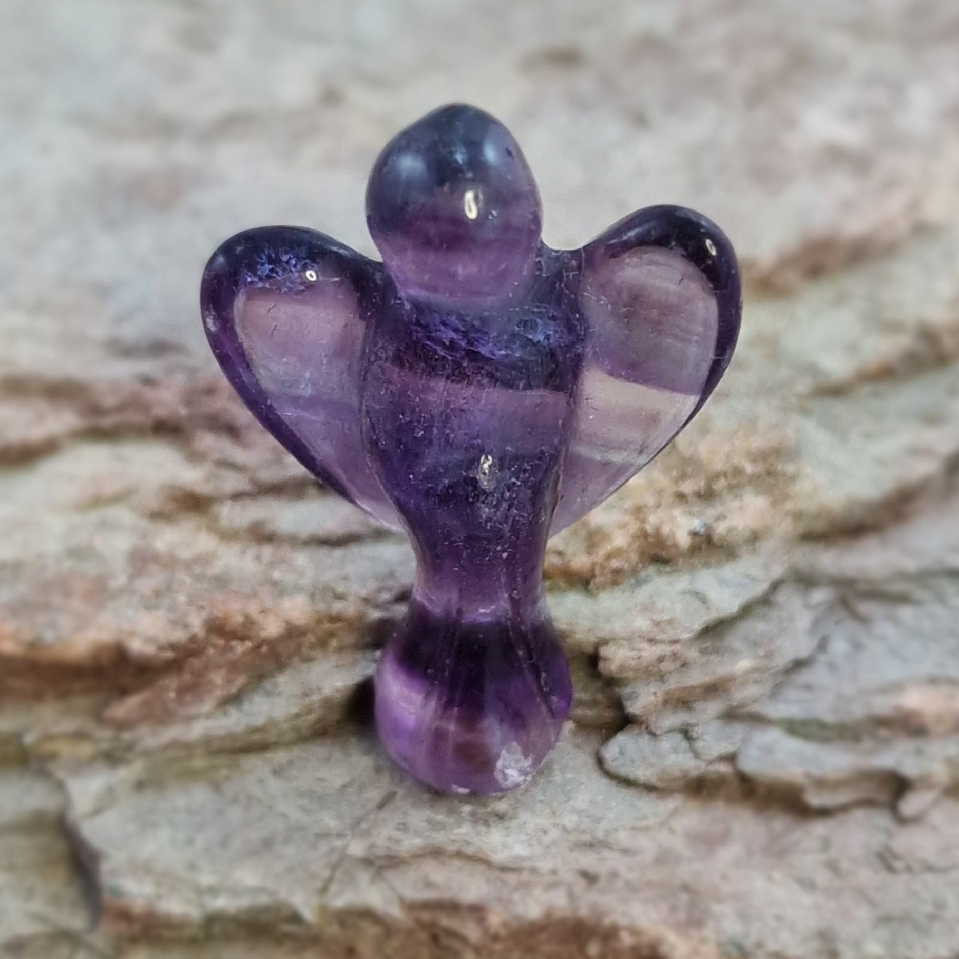 Fluorite Crystal Angel on a textured surface