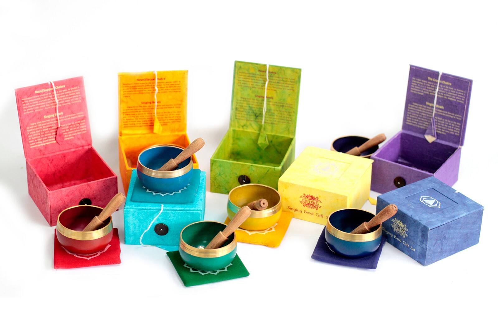 Set of colorful singing bowls with matching boxes on a white background