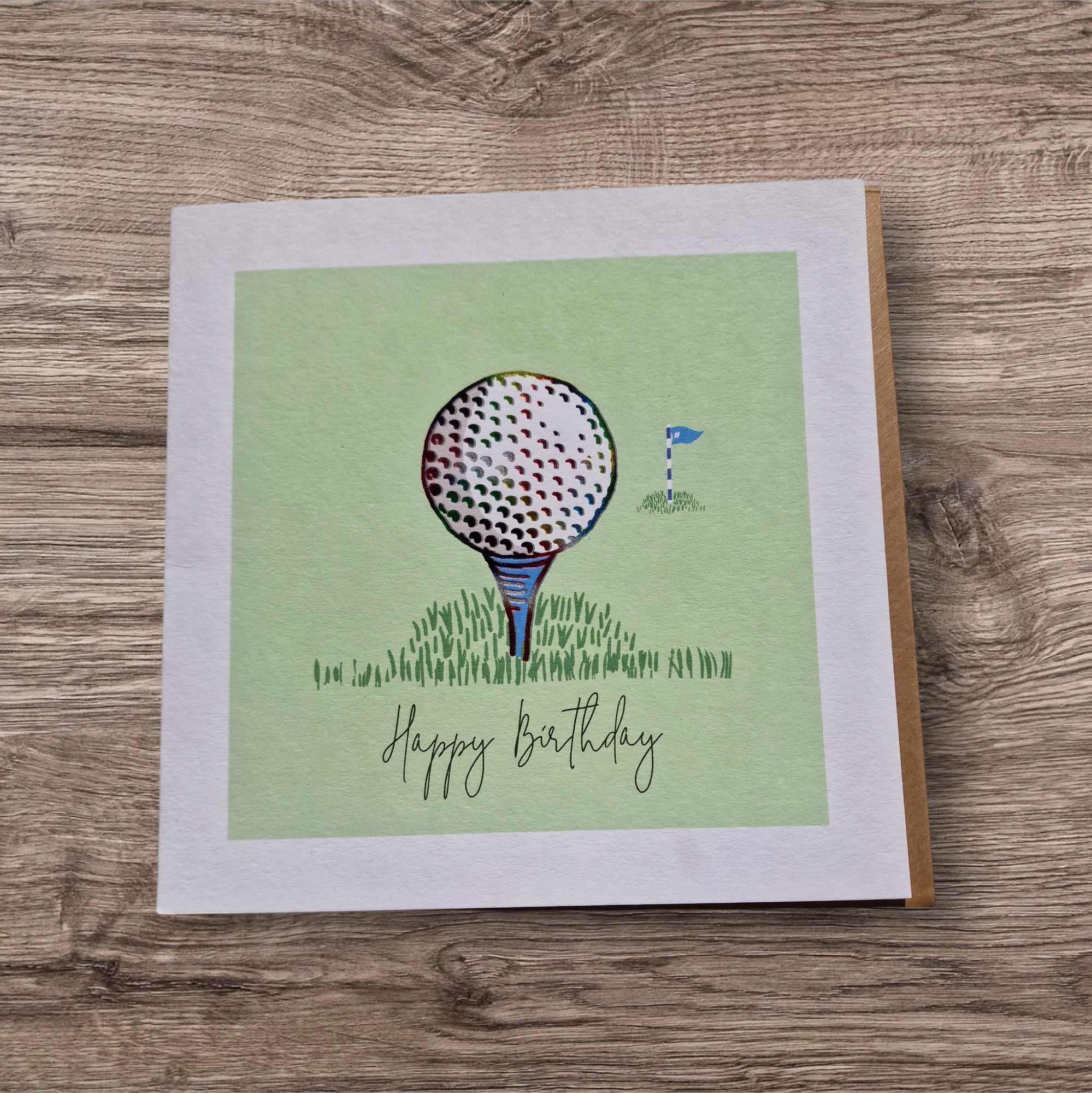 Happy Birthday Greeting card with golf ball and flag illustration on a wooden surface