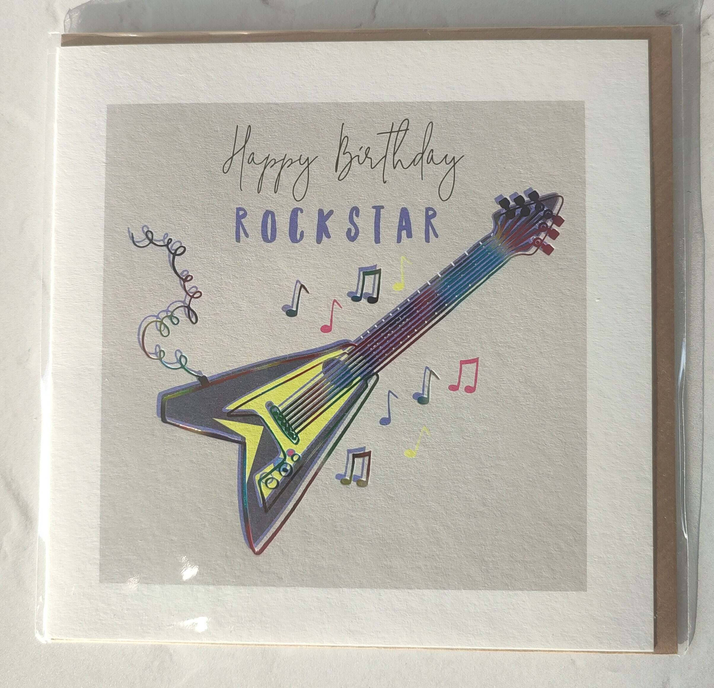 Greeting card with a colorful guitar illustration and 'Happy Birthday Rockstar' text on a gray background.