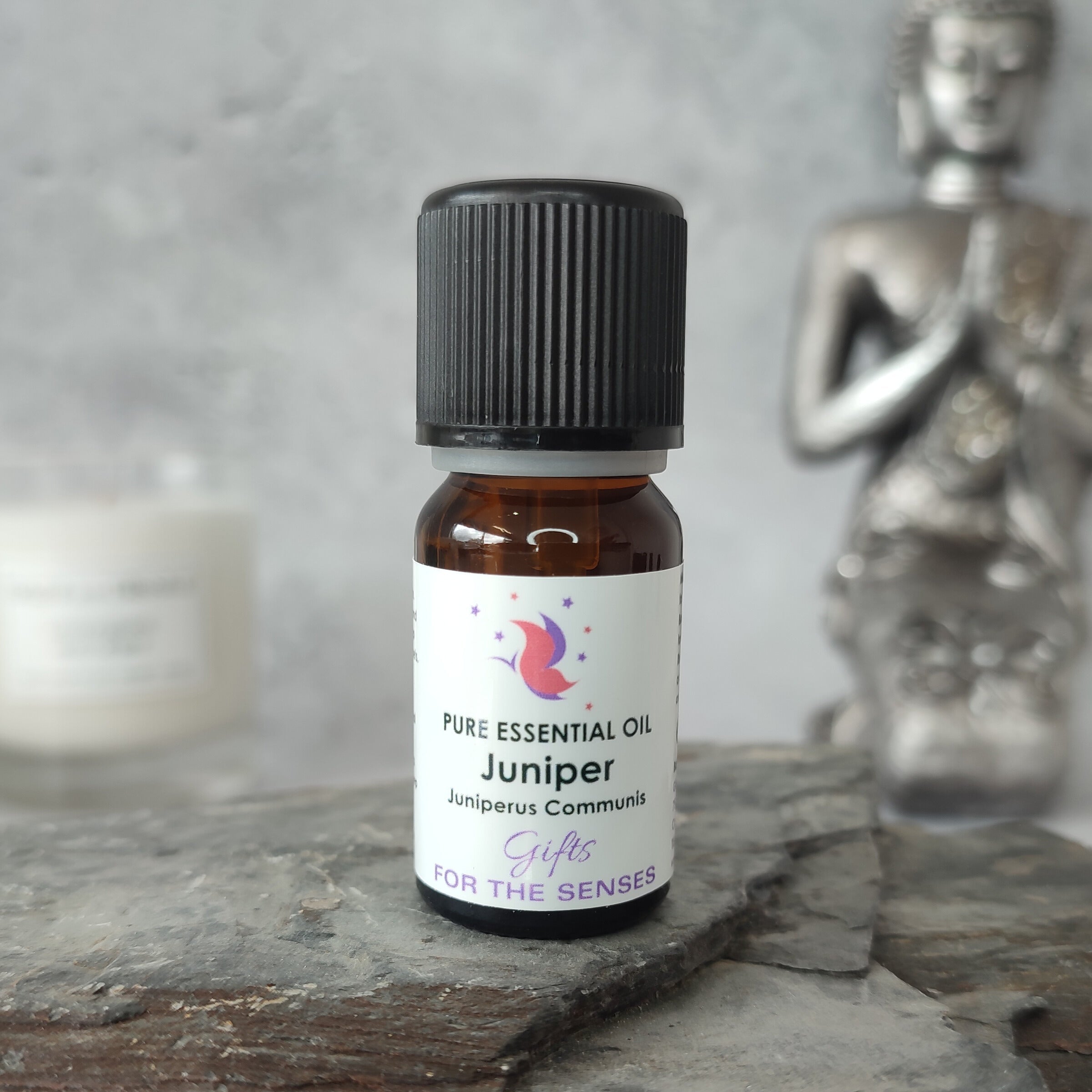 Bottle of Juniper essential oil on a wooden surface with a blurred background