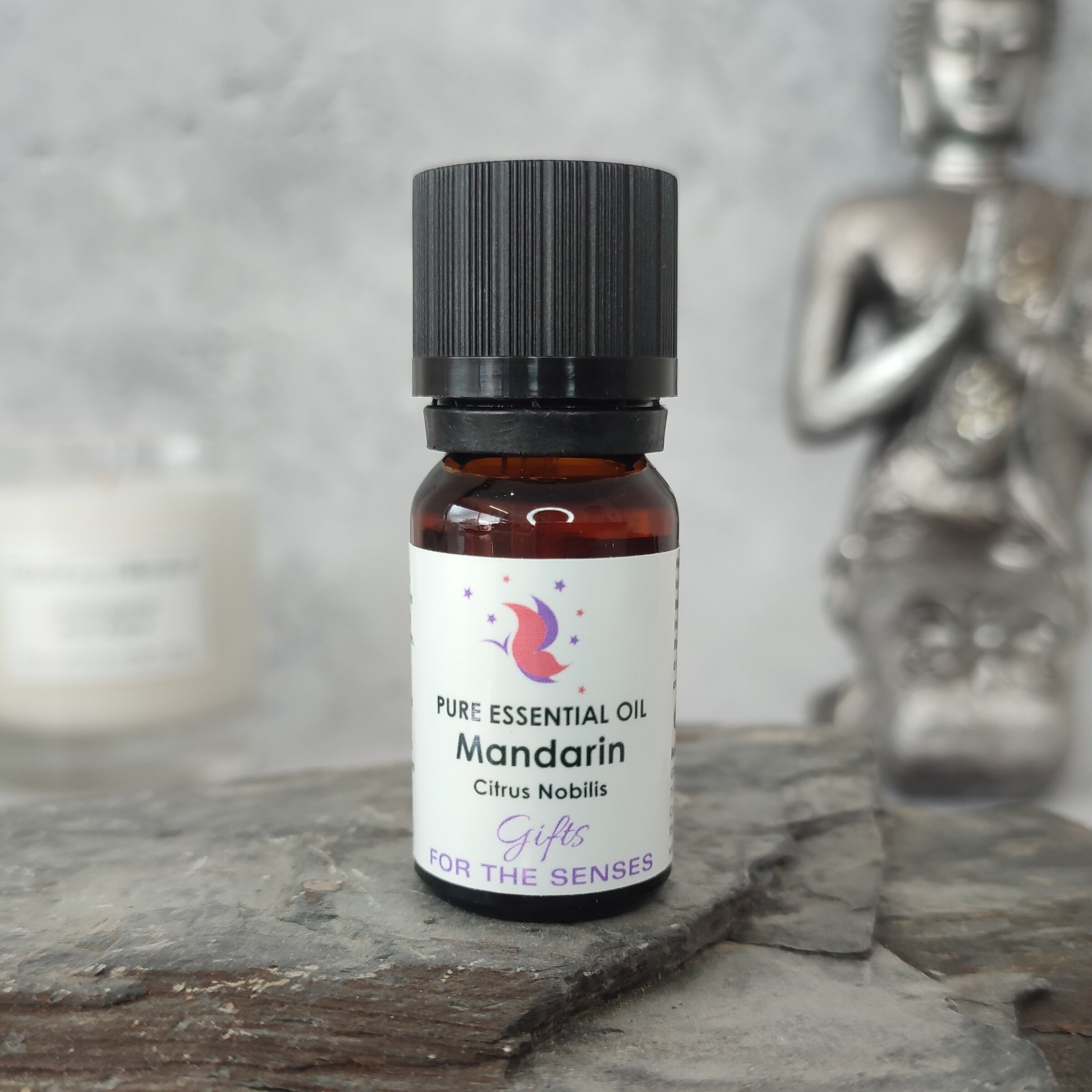 Mandarin essential oil bottle on a stone surface with a blurred background