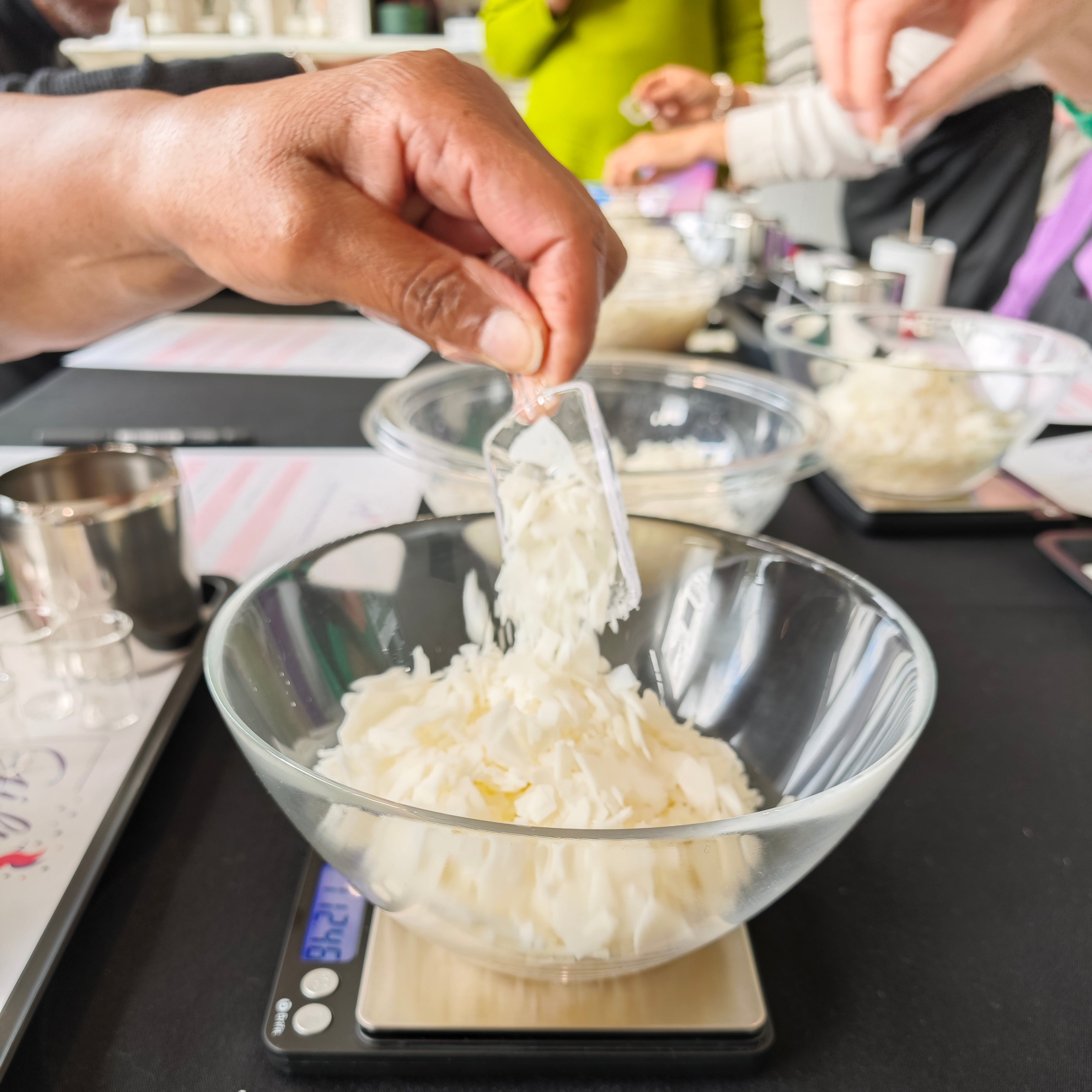 Person measuring wax on a digital scale