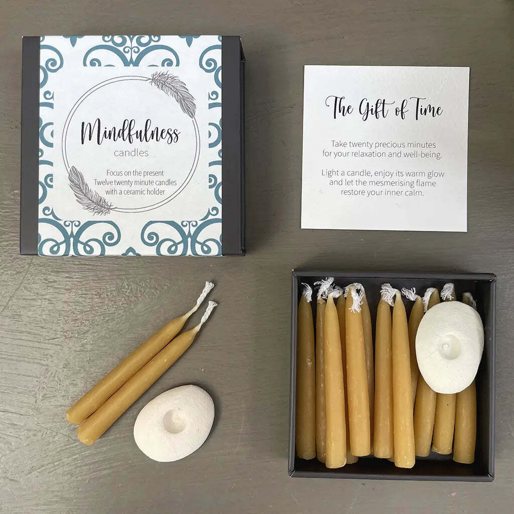 Set of mindfulness candles with packaging and instructions on a wooden surface