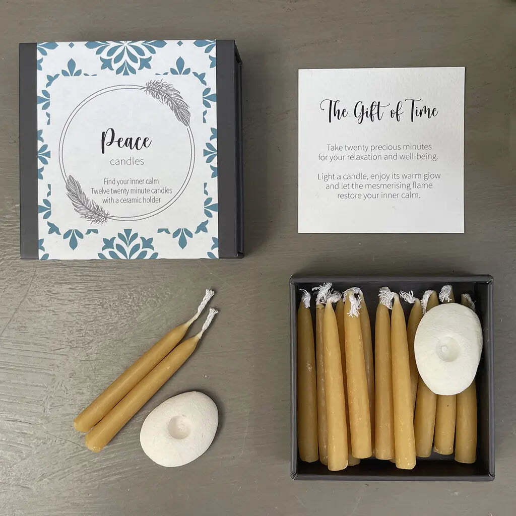 Set of peace candles with packaging and instructions on a wooden surface