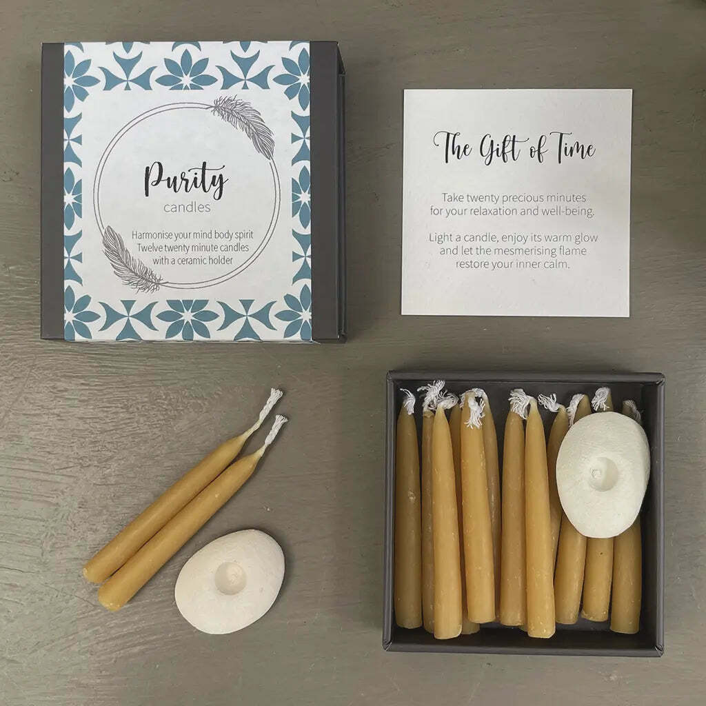 Set of beeswax candles with packaging and instructions on a wooden surface