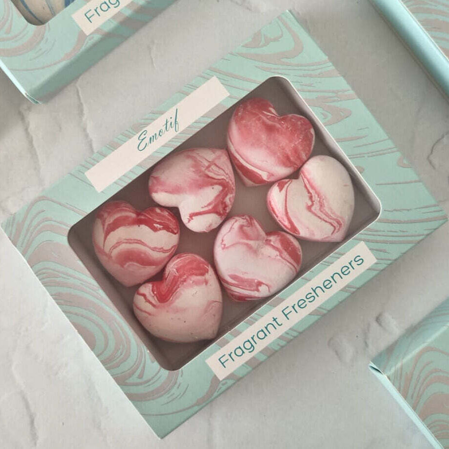 Pink marbled heart-shaped fragrant fresheners in a box labeled 'Emily'.