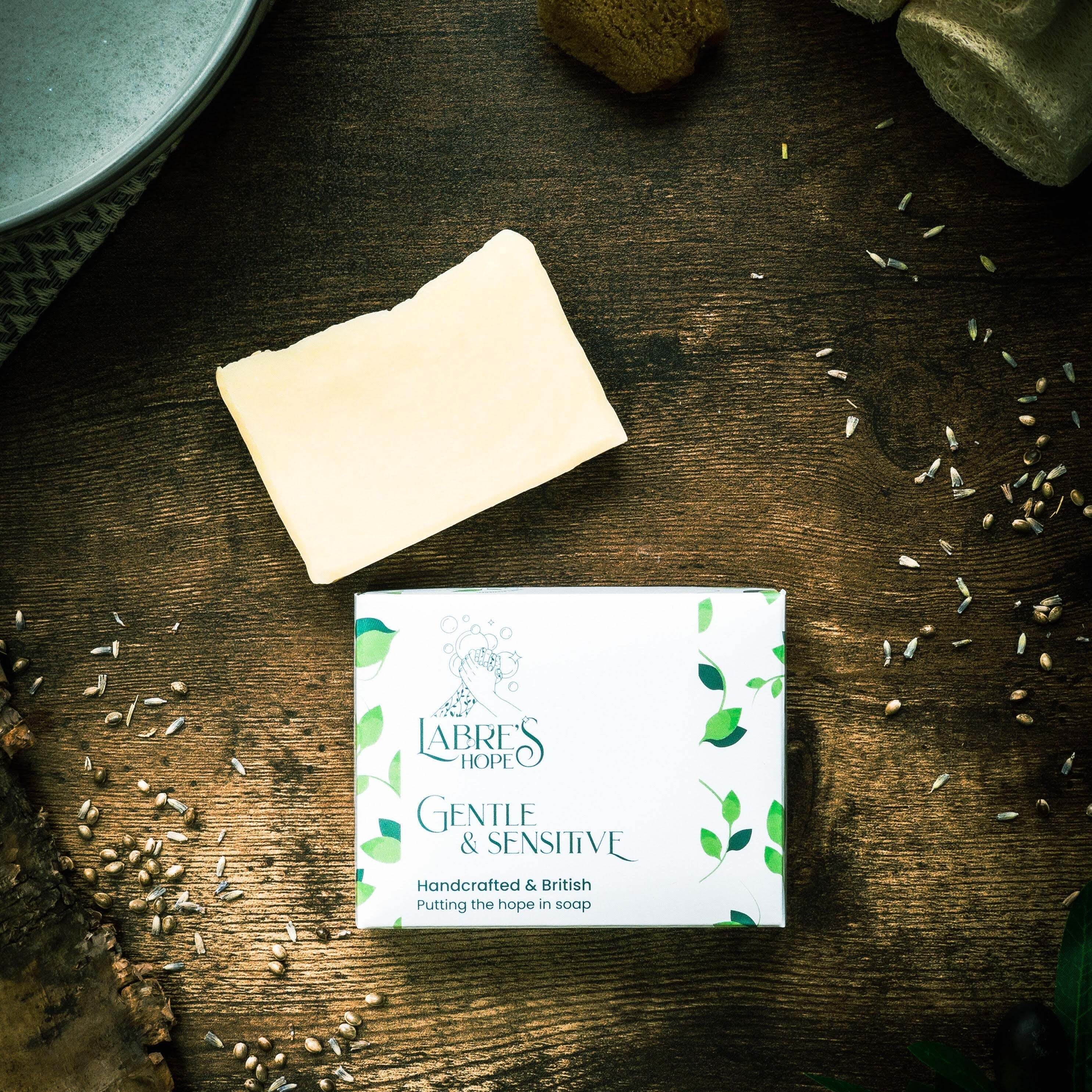 Bar of soap and packaging on a wooden surface with seeds scattered around