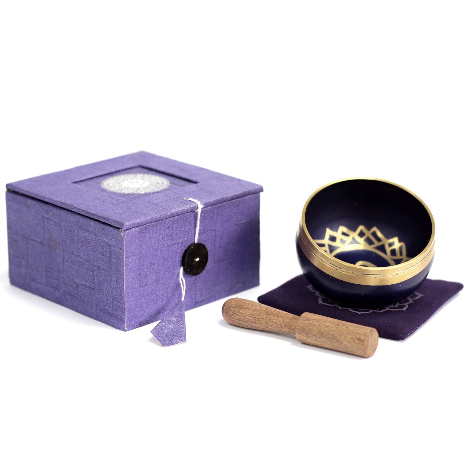 Purple singing bowl with gold interior and wooden handle next to a purple box on a white background