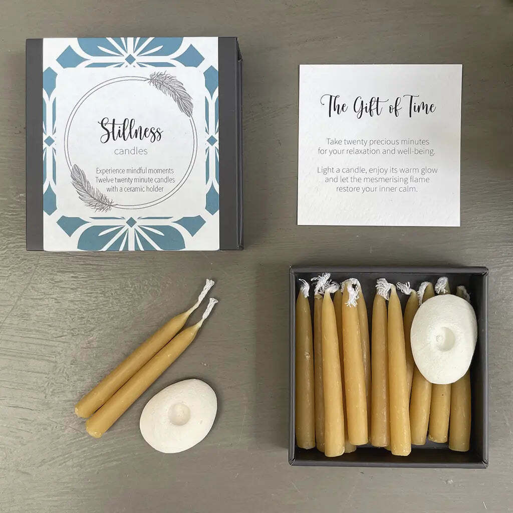 Set of beeswax candles with packaging and instructions on a wooden surface
