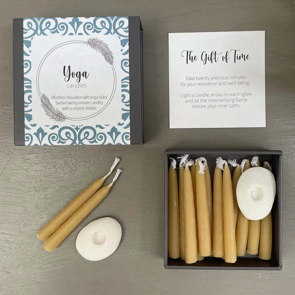 Yoga candles with packaging and instructions on a wooden surface